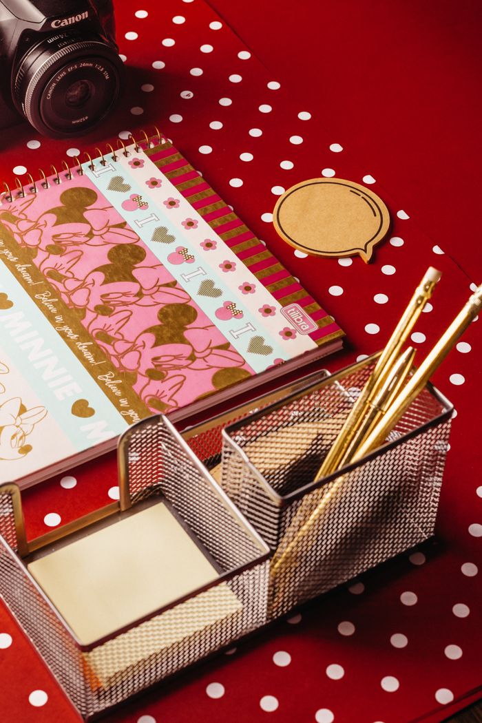 who-we-are Colorful stationery and camera placed on a red polka dot background, offering a playful workspace look.
